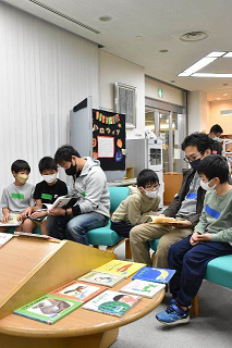 父が子に読み聞かせする様子