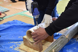 ドリルで竹に穴を開ける参加者