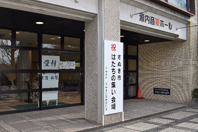 源内音楽ホールの正面玄関にはたちの集いの立て看板が立っている様子