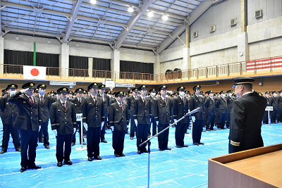 表彰を受ける数人が整列し、代表者が六車団長に敬礼する様子