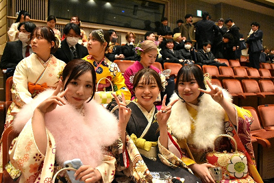 会場内の席に座りながらピースをする3名の振り袖姿の女性