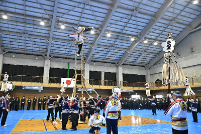 複数人で支えるはしごに2人で乗り、技を披露する様子