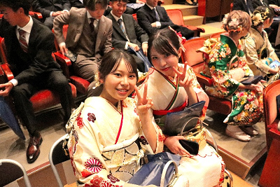 会場内の席に座りながらピースする2名の振り袖姿の女性