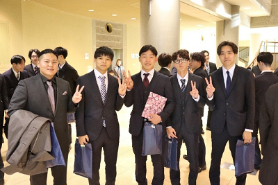 ピースをする4名のスーツ姿の男性